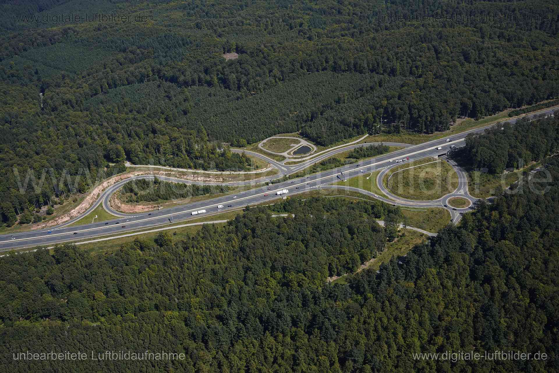 Titel: Anschlussstelle Rohrbrunn, Bildnummer: s561420, Ort / Stadt: Rohrbrunn, (Land)Kreis: Landkreis Aschaffenburg, Regierungsbezirk: Unterfranken, Bundesland: Bayern, Aufnahmedatum: 24.08.2024, Schlagwörter: Deutschland, , Anschlussstelle Rohrbrunn, Rohrbrunn, Spessart, Verkehrsführung, Kreisverkehr, Autobahn, Autobahn A3, BAB 3, Monat: August, Jahreszeit: Sommer, Tageszeit: Mittag / Nachmittag, Jahr: 2024, Flug ID: 20240824, Bildstatus: unbearbeitetes Rohbild, Bildabmessung: 7952 x 5304 Pixel
