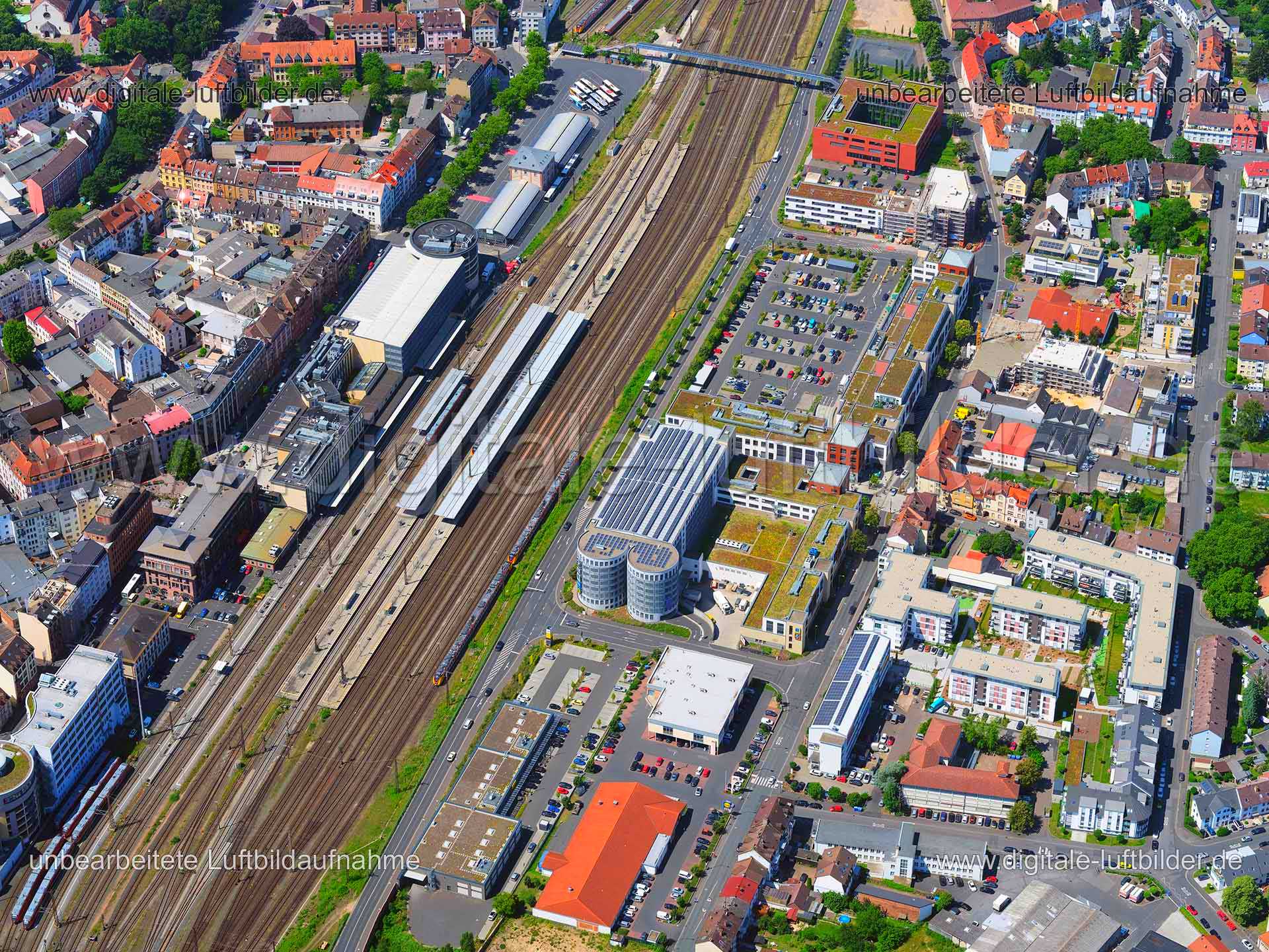 Titel: Hauptbahnhof Aschaffenburg, Bildnummer: f372230, Ort / Stadt: Aschaffenburg, (Land)Kreis: kreisfreie Stadt Aschaffenburg, Regierungsbezirk: Unterfranken, Bundesland: Bayern, Aufnahmedatum: 24.06.2020, Schlagwörter: Luftbild, Luftbilder, Luftbildfotografie, Luftaufnahme, Luftbildaufnahme, Luftfoto, Vogelperspektive, Vogelansicht, Deutschland, Schräg- und Senkrecht-Luftaufnahmen, Orthofotografie, Hauptbahnhof, Bahnhof, Zug, Gleise, Bahn, Deutsche Bahn, Monat: Juni, Jahreszeit: Sommer, Tages